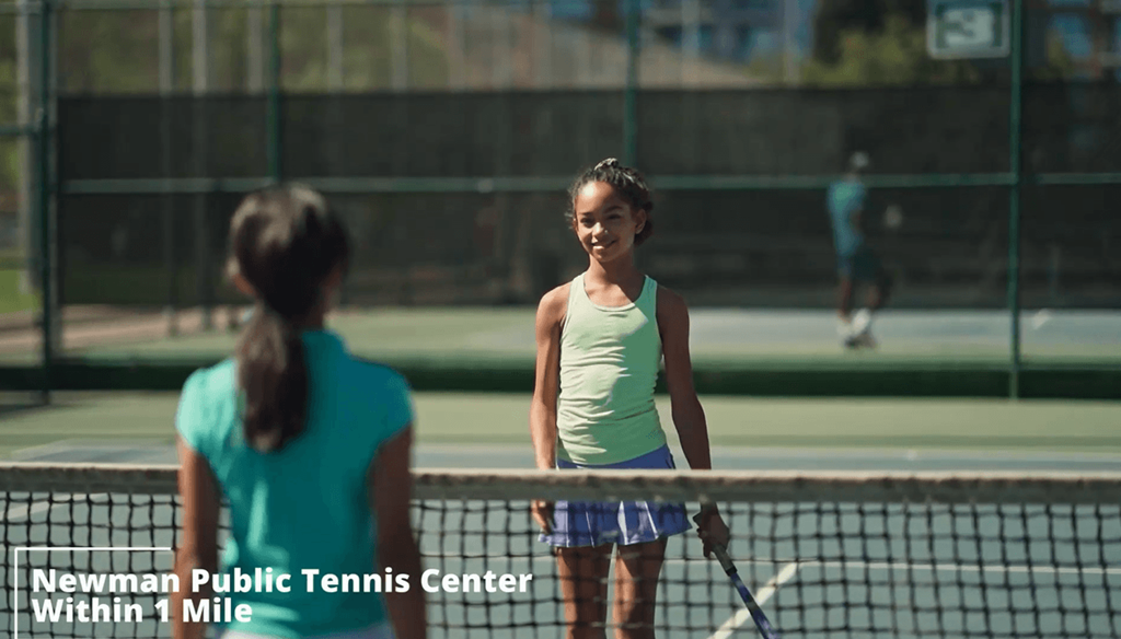 two young women playing tennis on a tennis court