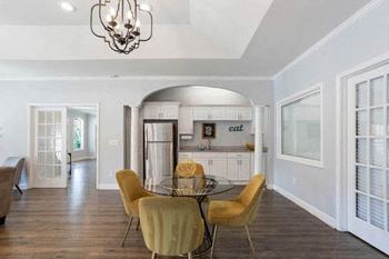 a table and chairs by the kitchenette in the clubhouse at The Onyx Hoover Apartments