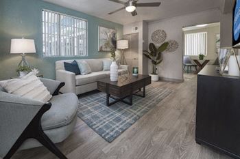 the living room of the model at Terraces at Clearwater Beach with designer paint colors, wood-style floors, and model furnishings