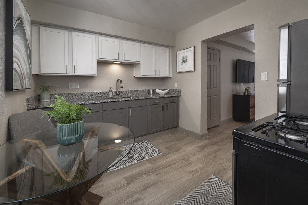 Kitchen with wood-style floors, white upper and gray lower cabinets, and stainless steel appliances at Terraces at Clearwater Beach, Clearwater, Florida