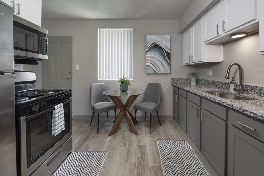 Kitchen with granite countertops, stainless steel appliances, and wood-style floors at Terraces at Clearwater Beach, Clearwater, 33756