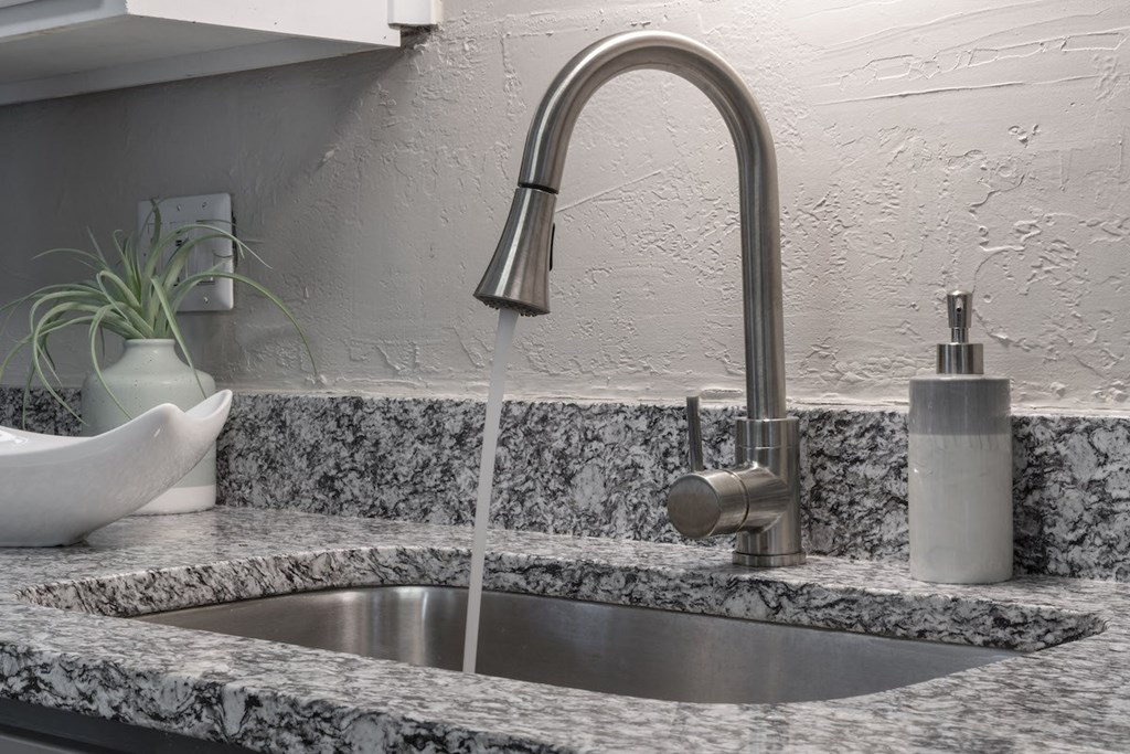 modern fixture with pull-down sprayer and under-mount sink in granite countertop in kitchen at Terraces at Clearwater Beach, Clearwater, Florida