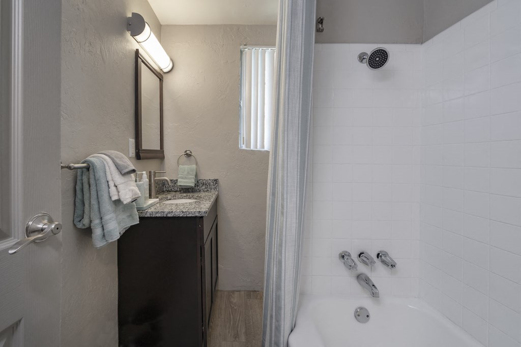 Bathroom with granite vanity countertop and over mirror lighting and shower/tub at Terraces at Clearwater Beach, Clearwater