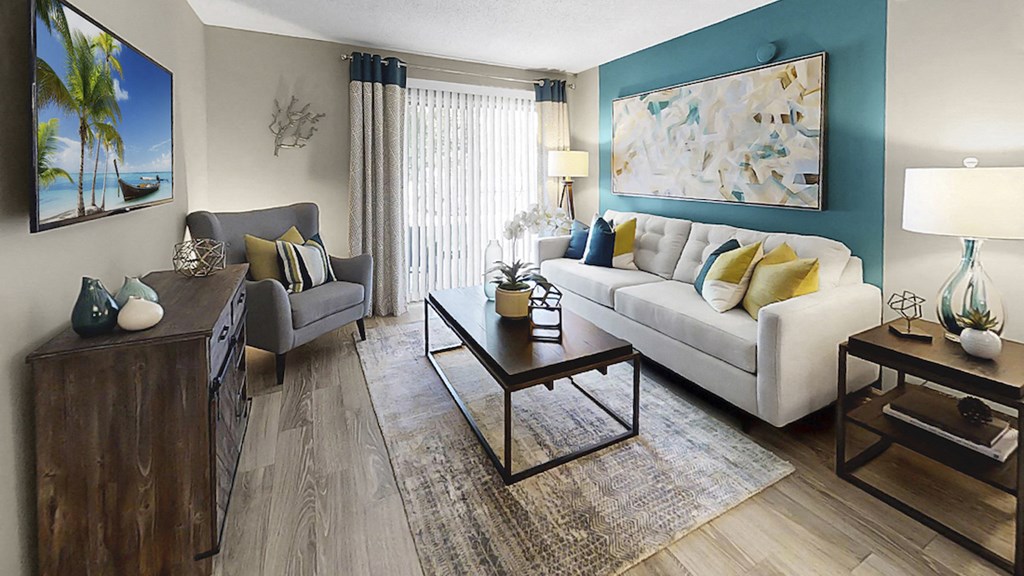 Living room with plank-style flooring, patio access, and accent wall at The Madison Franklin, Tennessee, 37064