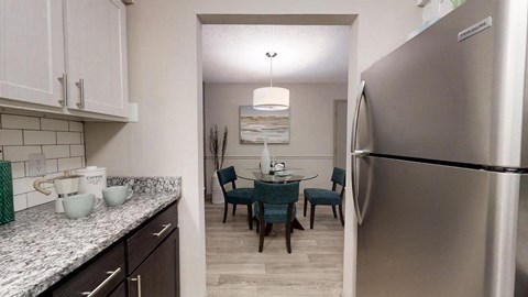 a kitchen and dining room with a stainless steel refrigerator