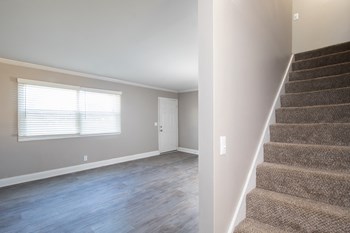 carpeted stairway and large windows in living room carpeted stairway and large windows in living room at The Kensington Apartments, Huntsville - Photo Gallery 5