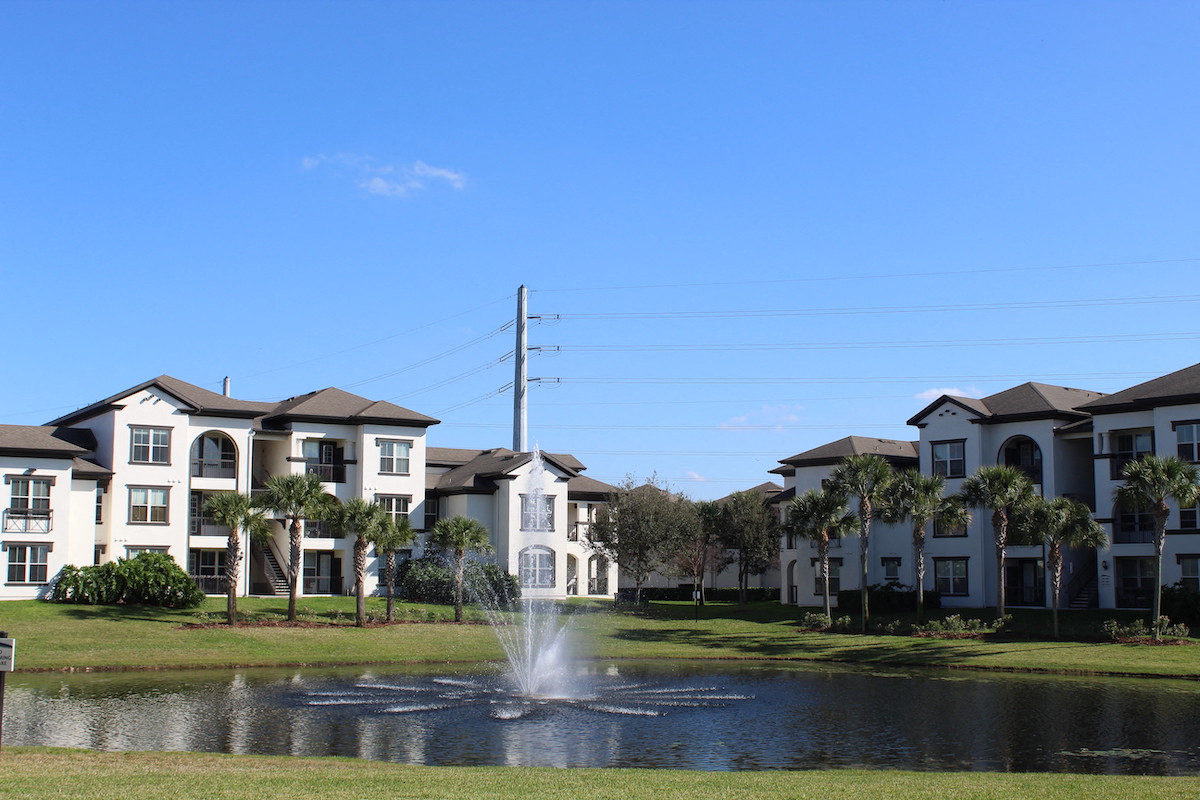 Fountain in pond beside apartment homes at Lake Nona Water Mark