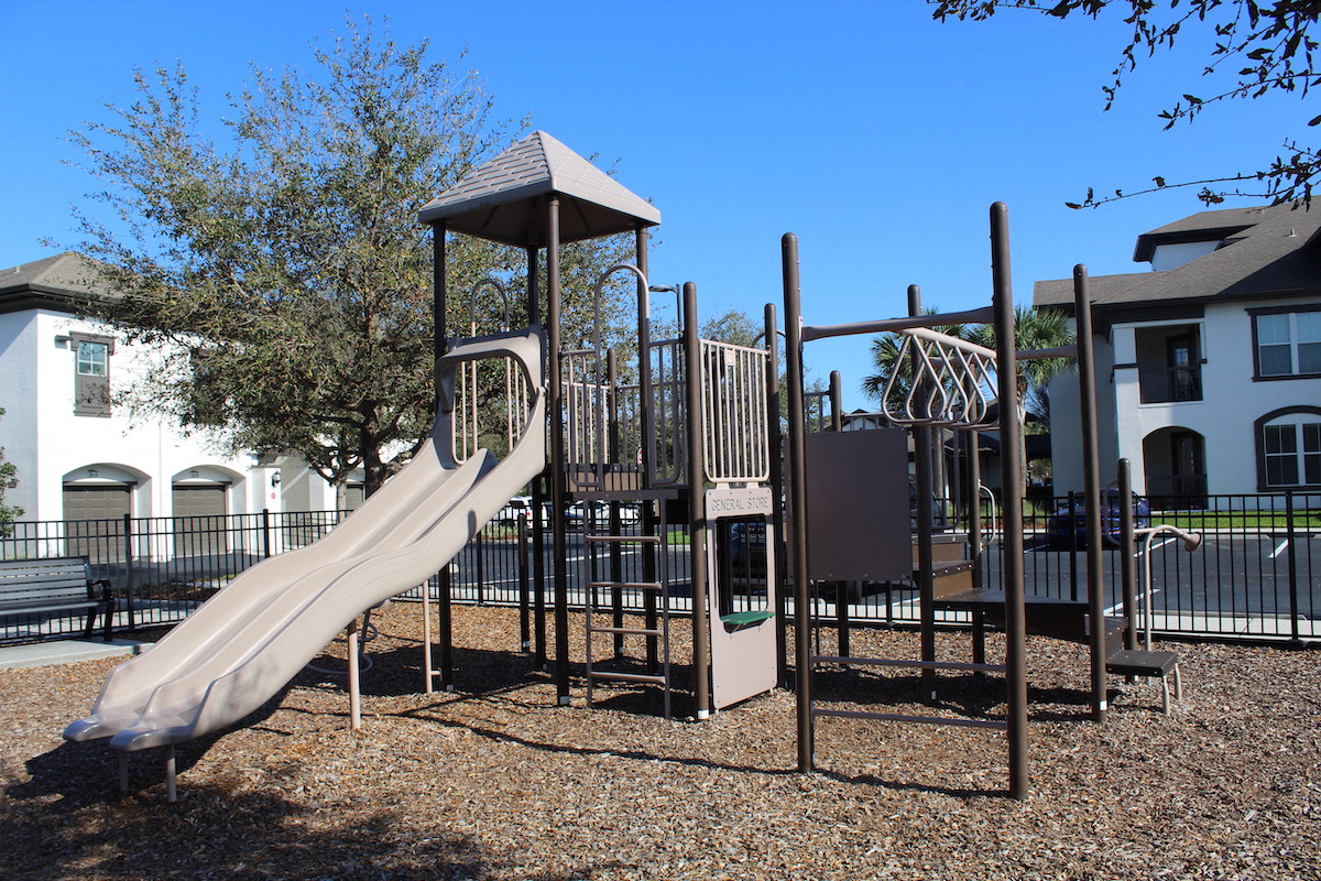 Modern Playground equipment in fenced in playground in Orlando, FL 32827