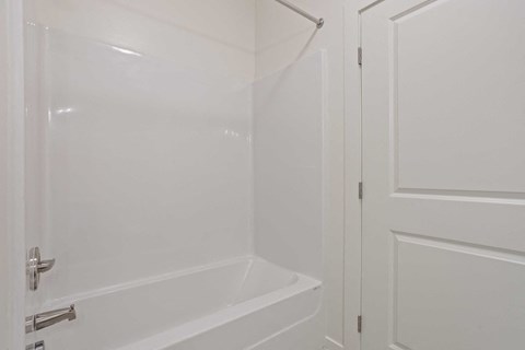 a white bathroom with a shower and a tub