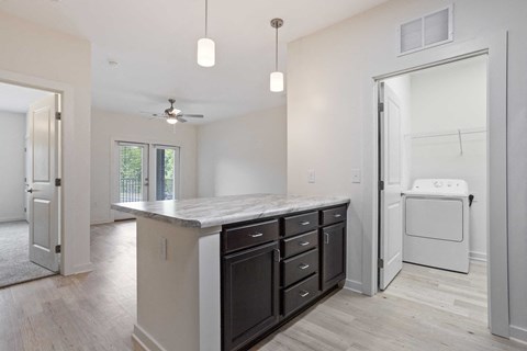 a renovated kitchen with a counter top and a laundry room