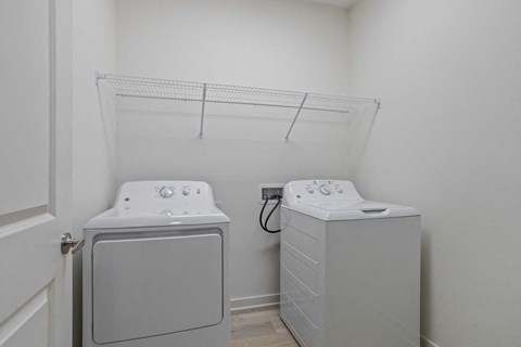 a washer and dryer in a laundry room with a rack on the wall
