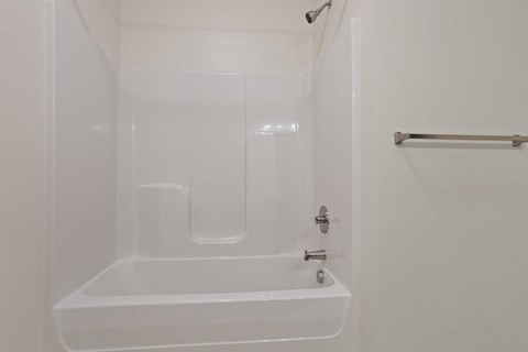 a white bathroom with a shower and a sink