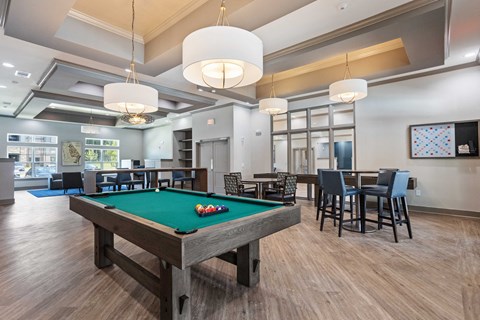 a clubhouse with a pool table and dining tables