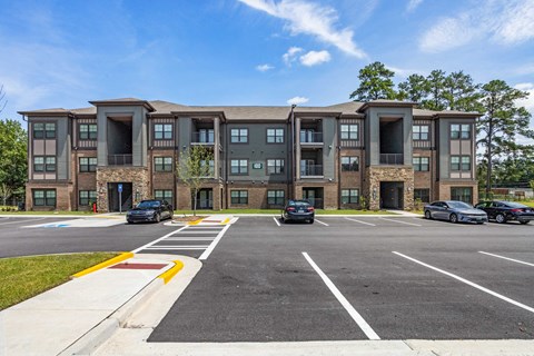 a large apartment building with cars parked in a parking lot