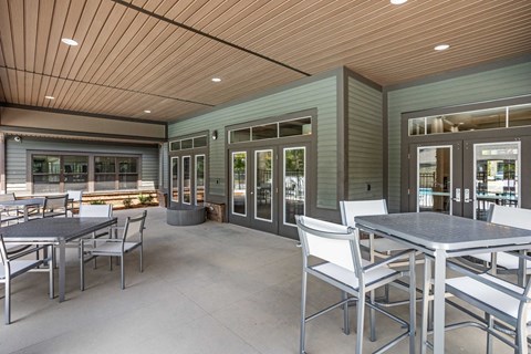 a patio with tables and chairs and a fire pit