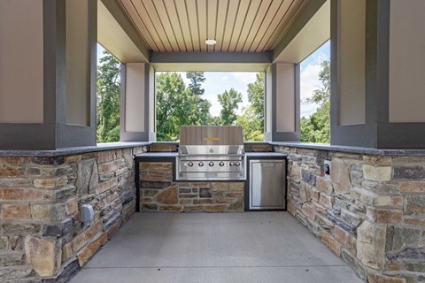 the outdoor kitchen is equipped with a grill and a large window