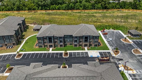 an aerial view of a building with cars parked in front of it