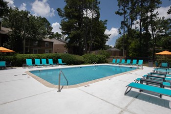 Zelda-Pointe-Gallery-11 sparkling pool, lounge chairs, and picnic tables with bright umbrellas - Photo Gallery 3