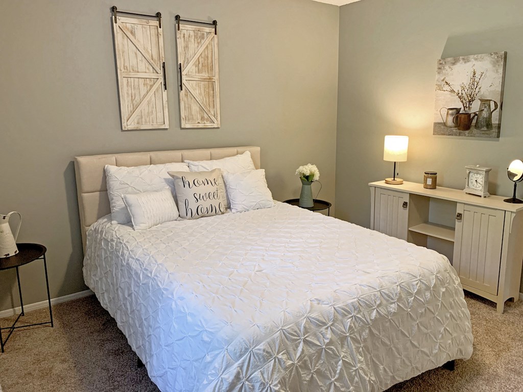 bedroom with carpeting, model bed and furnishings