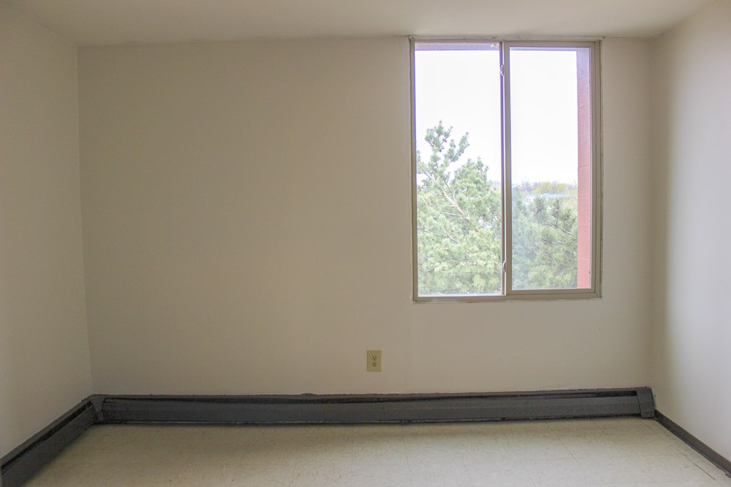 A room with a window and a wall socket.