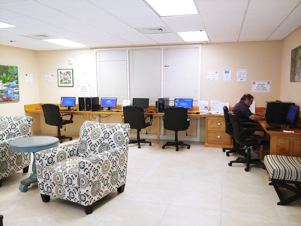 resident enjoying the computer lounge at B'nai B'rith I, II, & III apartments in deerfield beach
