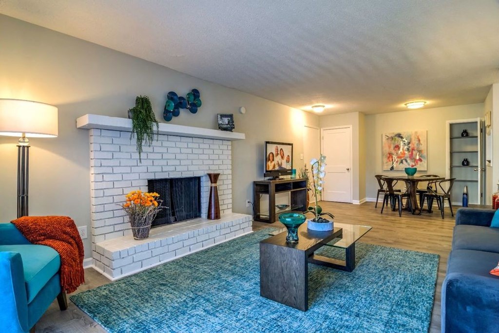 living room with brick fireplace, wood-style flooring, and model furnishings at the Onyx Hoover