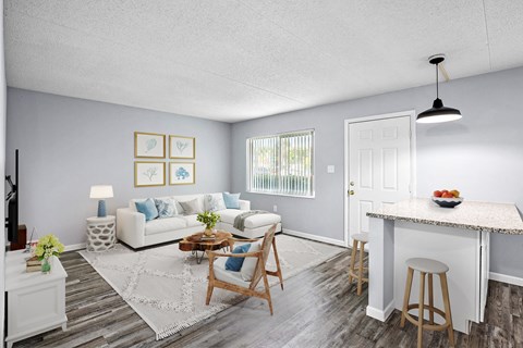 A living room with a white couch, a coffee table, and a dining table.
