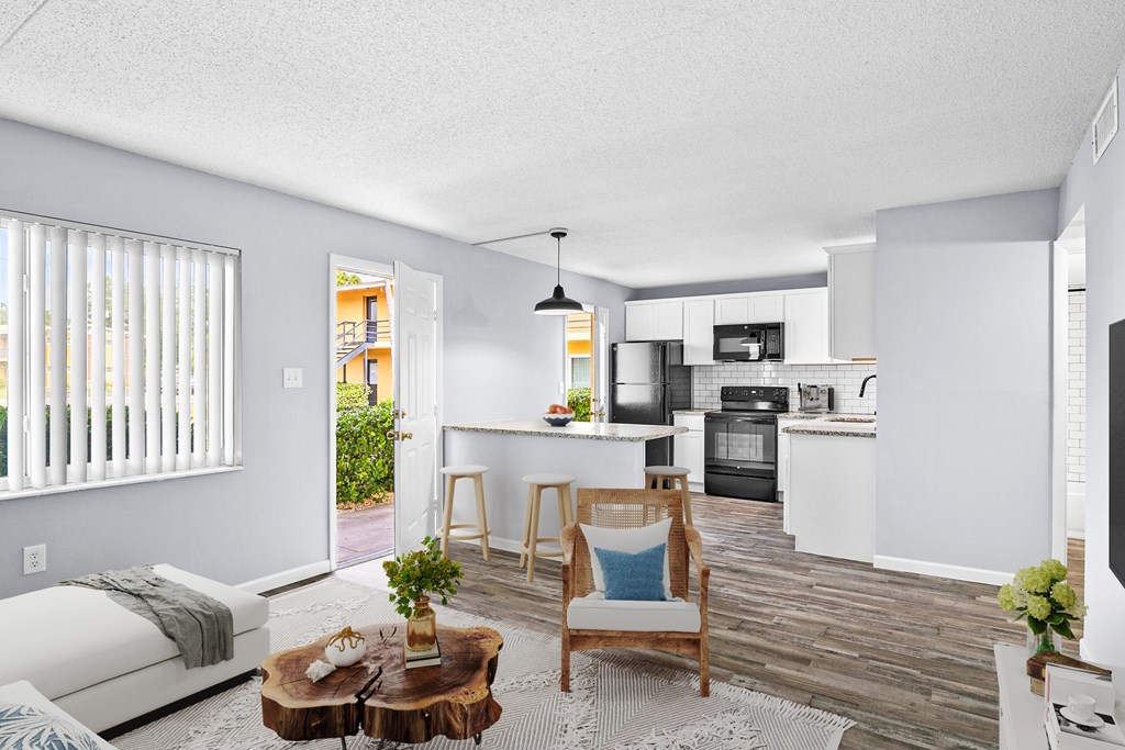 A modern kitchen with white cabinets and a wooden floor.