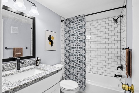 A bathroom with a black and white shower curtain.