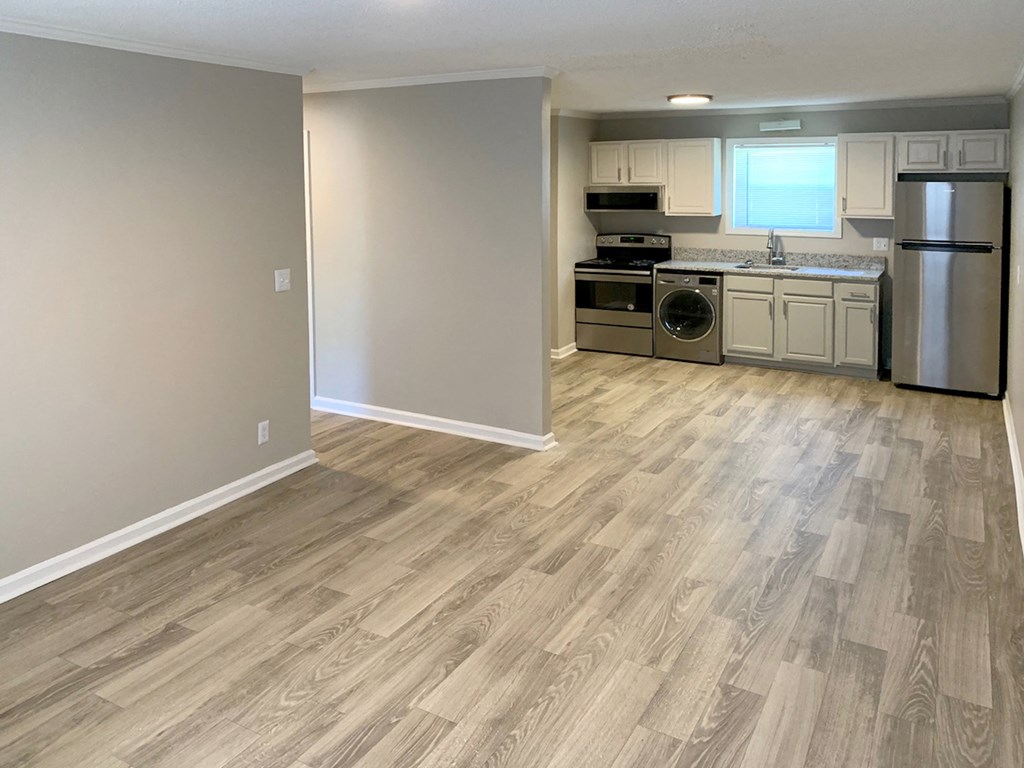 open living room and kitchen area with hardwood-style flooring and stainless steel appliances