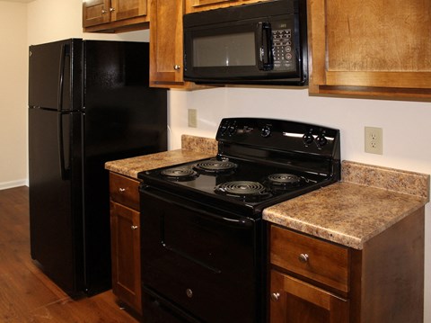 a kitchen with black appliances and granite counter tops and a black refrigerator