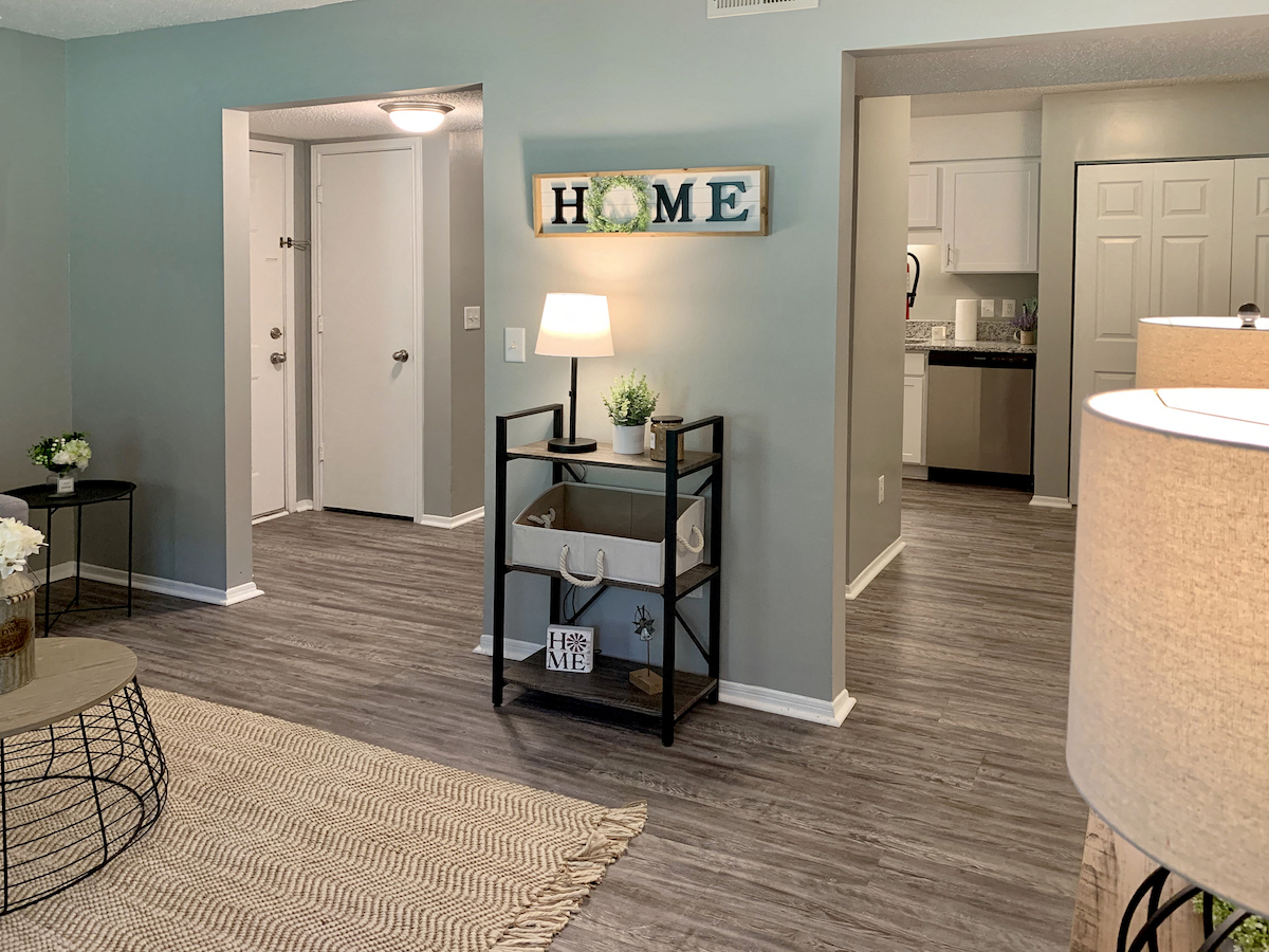a living room with a lamp and a table with a plant on top of it