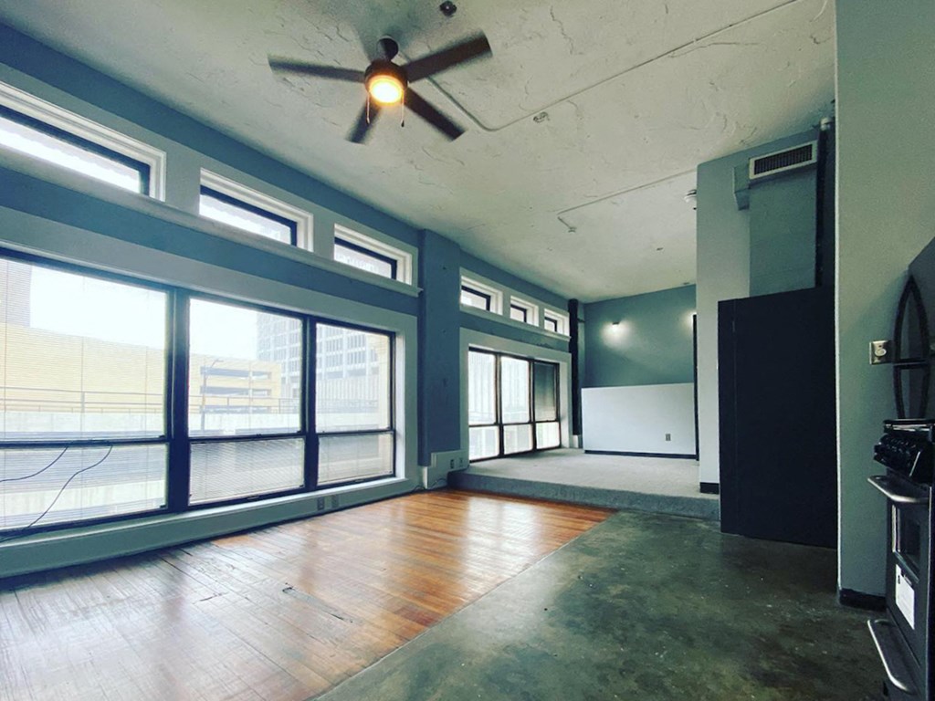 large windows in loft with ceiling fan and hardwood and concrete floors at Jemison Flats, Birmingham, AL, 35203