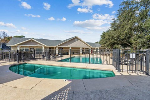 A swimming pool in front of a house.