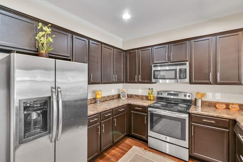 A kitchen with brown cabinets and stainless steel appliances.
