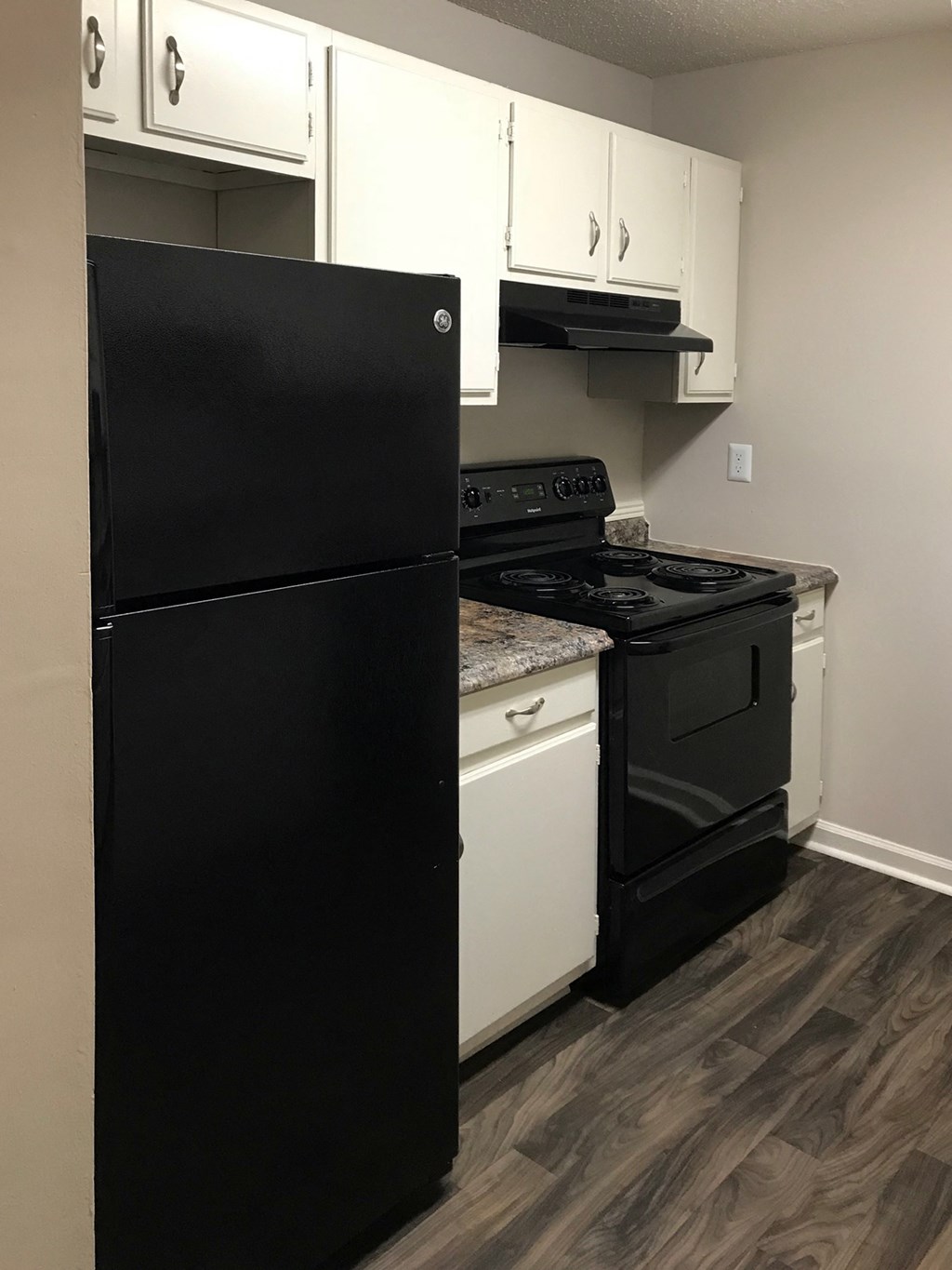 kitchen with black fridge and oven, range, and hardwood-style floor
