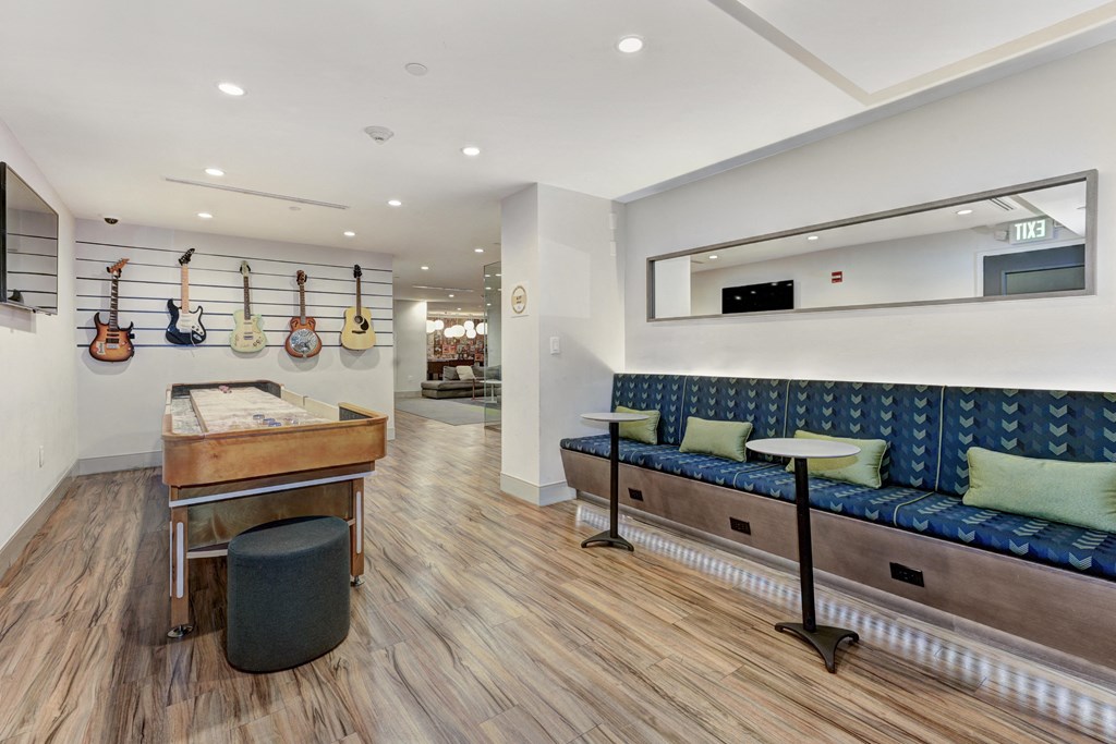 a room with a foosball table and a couch with green pillows