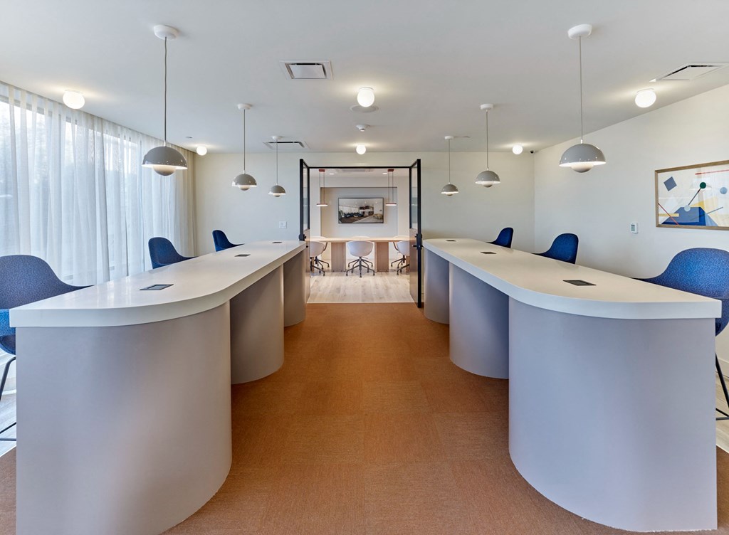 a conference room with blue chairs and white tables