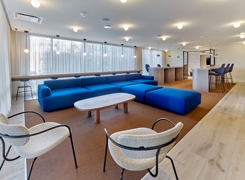 a living room with blue couches and chairs and a table