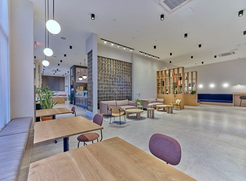 a large lobby with tables and chairs and a library