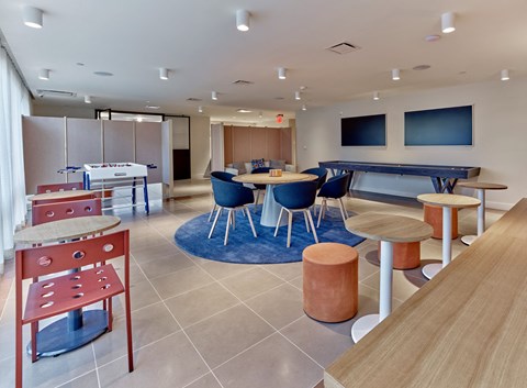 a common room with tables and chairs and a pool table