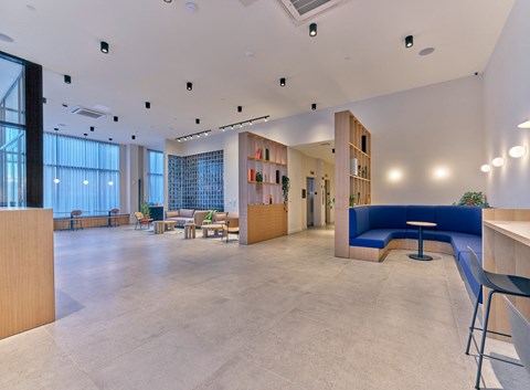 a large lobby with blue couches and chairs and a table