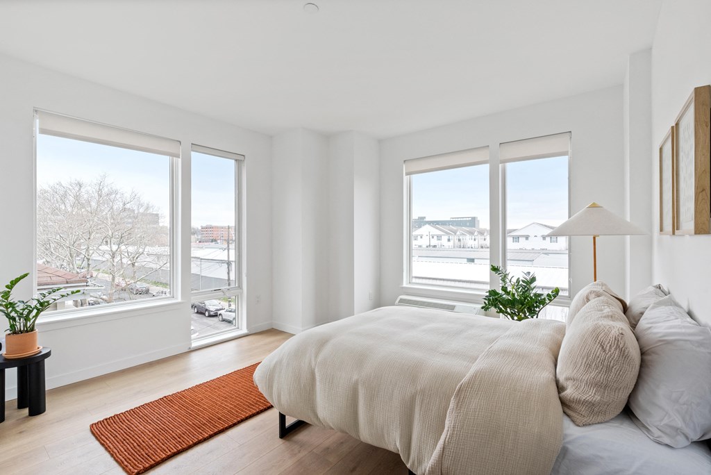 a bedroom with a bed and three windows
