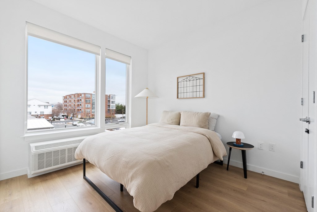a bedroom with a large window and a bed