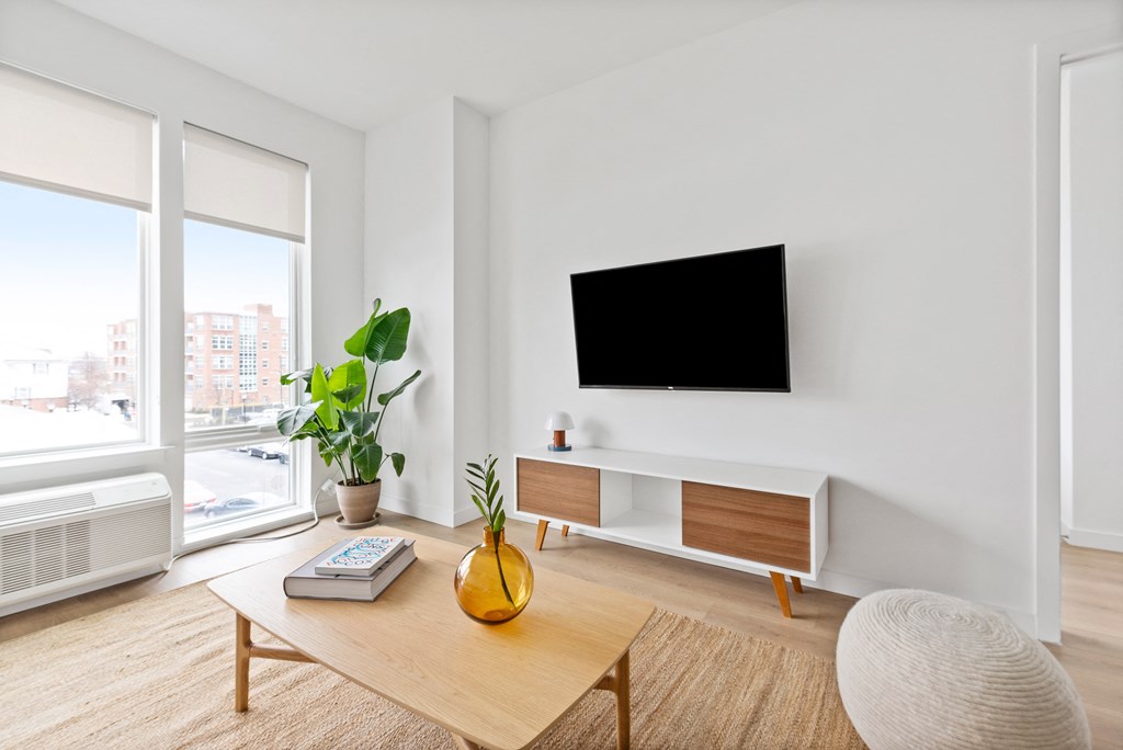a living room with a table and a television on the wall