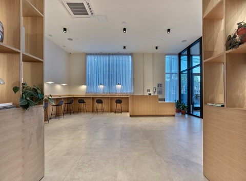 a large room with a counter and chairs and a window