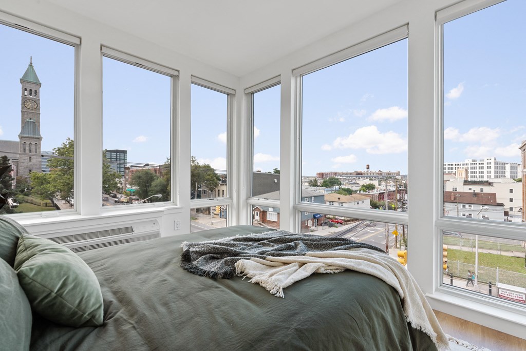 a bedroom with a bed and a view of the city