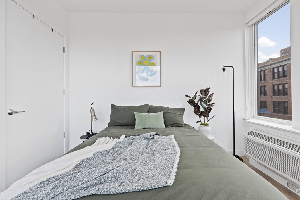 a bedroom with a large bed and a large window