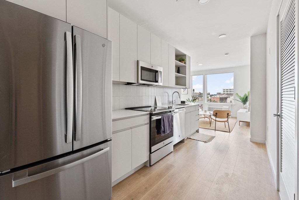 a kitchen with white cabinets and a stainless steel refrigerator