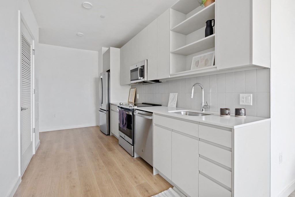 a kitchen with white cabinets and stainless steel appliances